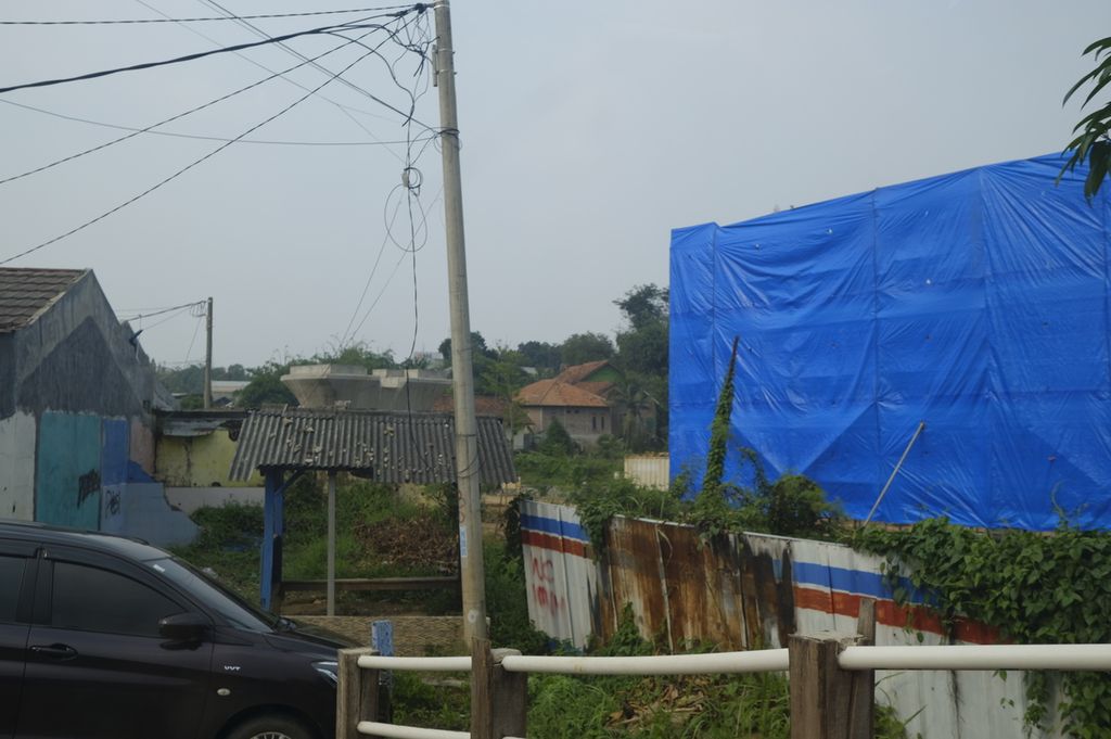 Terpal biru tampak terpasang menutupi tiang penyangga proyek Kereta Cepat Jakarta-Bandung di wilayah Jatiluhur, Purwakarta, Jawa Barat, Selasa (8/3/2022). Terpal itu membatasi pandangan warga dari arah perumahan Puri Yasmin.