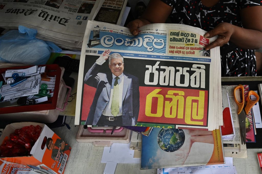 Penjual memegang surat kabar dengan halaman depan foto presiden terpilih Sri Lanka Ranil Wickremesinghe di sebuah kios di Colombo, 21 Juli 2022. Wickremesinghe pernah enam kali menjabat perdana menteri. 