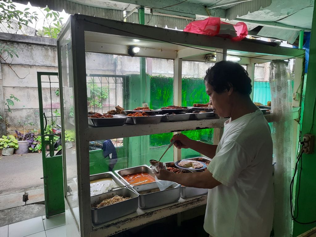 Pedagang nasi rumahan, Sartodiharjo (54), berjualan di balik gedung-gedung tinggi Jalan Sudirman, Jakarta, Selasa (21/3/2023). Ia mengatakan, para pekerja kantoran ramai mengunjungi warungnya menjelang akhir bulan.