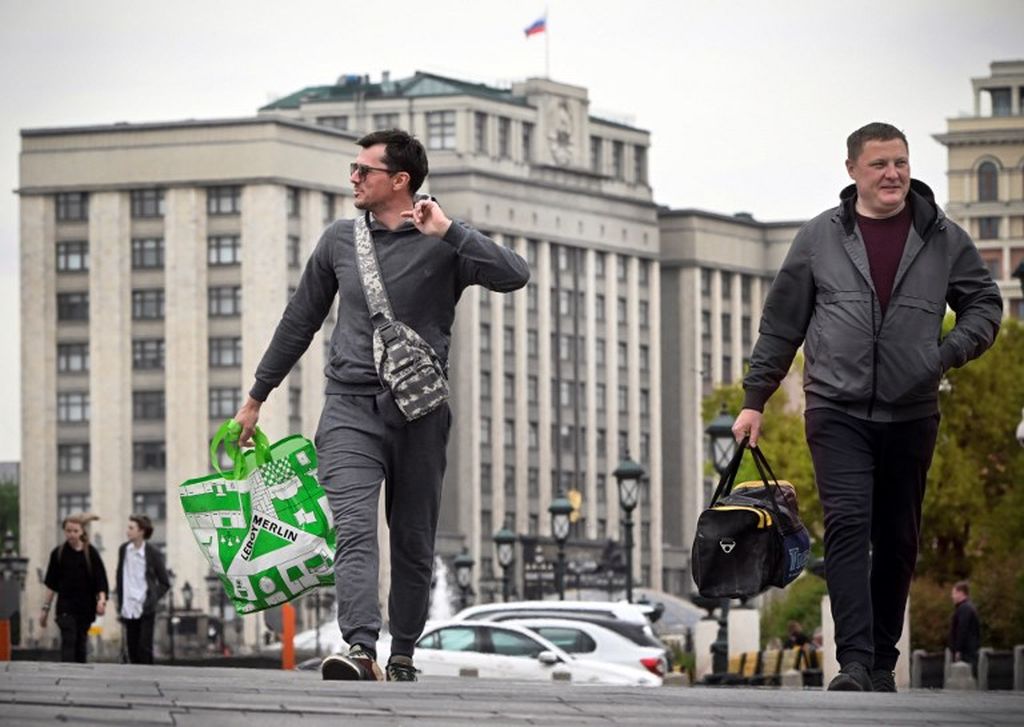 Seorang pria membawa tas belanja Leroy Merlin, Perancis, saat melintas di depan Duma Negara Rusia (Majelis Rendah Parlemen Rusia) di Moskwa, Rusia, 6 September 2022. 
