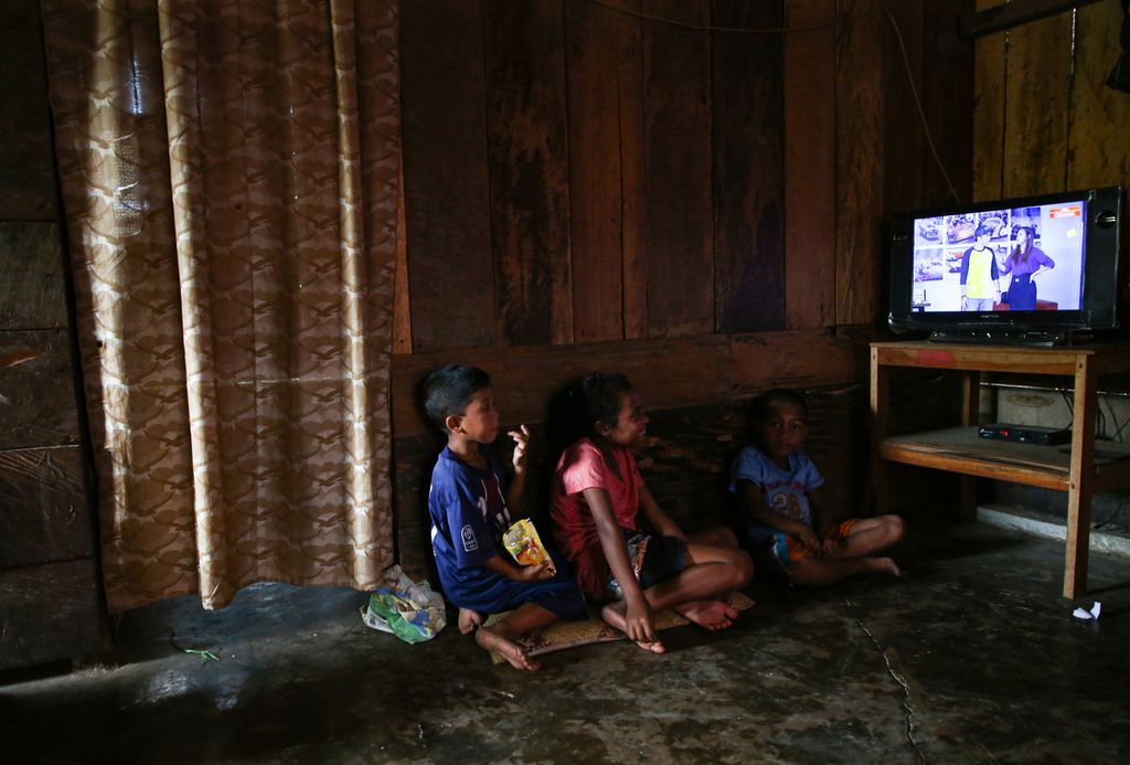 Anak-anak menonton televisi di salah satu rumah warga di Kampung Lale, Desa Wewo, Kecamatan Satar Mese, Kabupaten Manggarai, Nusa Tenggara Timur, Selasa (5/10/2021). Listrik di desa tersebut menyala sejak November 2011 bersamaan dengan beroperasinya PLTP Ulumbu.