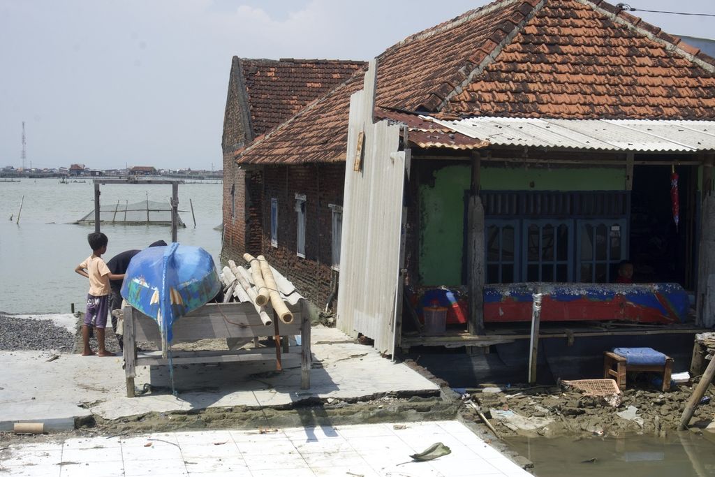 Warga memperbaiki kapal yang biasa dijadikan alat transportasi saat air rob pasang di Dukuh Timbulsloko, Desa Timbulsloko, Kecamatan Sayung, Demak, Jawa Tengah, Selasa (21/3/2023). 
