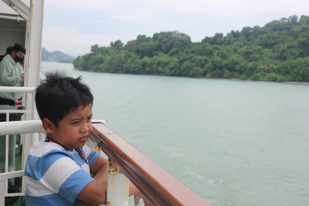 Seorang anak yang menumpangi kapal feri penyeberangan Merak-Bakauheni sedang menyaksikan hamparan laut Jawa di Selat Sunda, Jumat (23/12/2022)