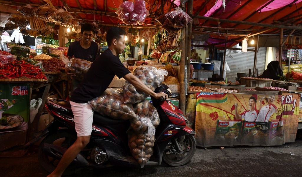 Pekerja mengangkut kantong berisi kentang menggunakan sepeda motor di Pasar Anyar, Kota Tangerang, Banten, Selasa (29/3/2022).