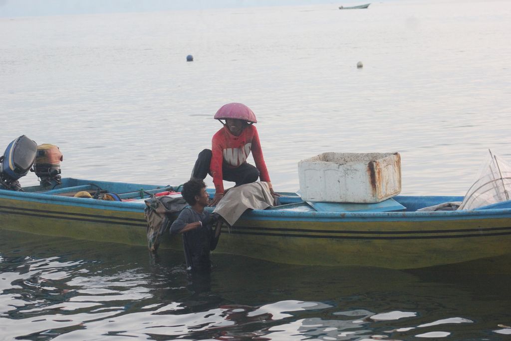 Dengan cara memanggul menyeberangi pantai, seorang nelayan membawa seekor tuna segar yang baru saja ditangkap menuju tempat penimbangan di Desa Sangowo, Kecamatan Morotai Timur, Kabupaten Pulau Morotai, Maluku Utara, Rabu (27/7/2022).