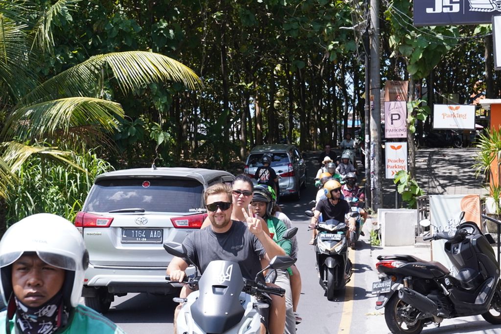 Two foreign tourists (center)  riding without wearing helmets in Canggu, Bali, Monday (24/4/2023)