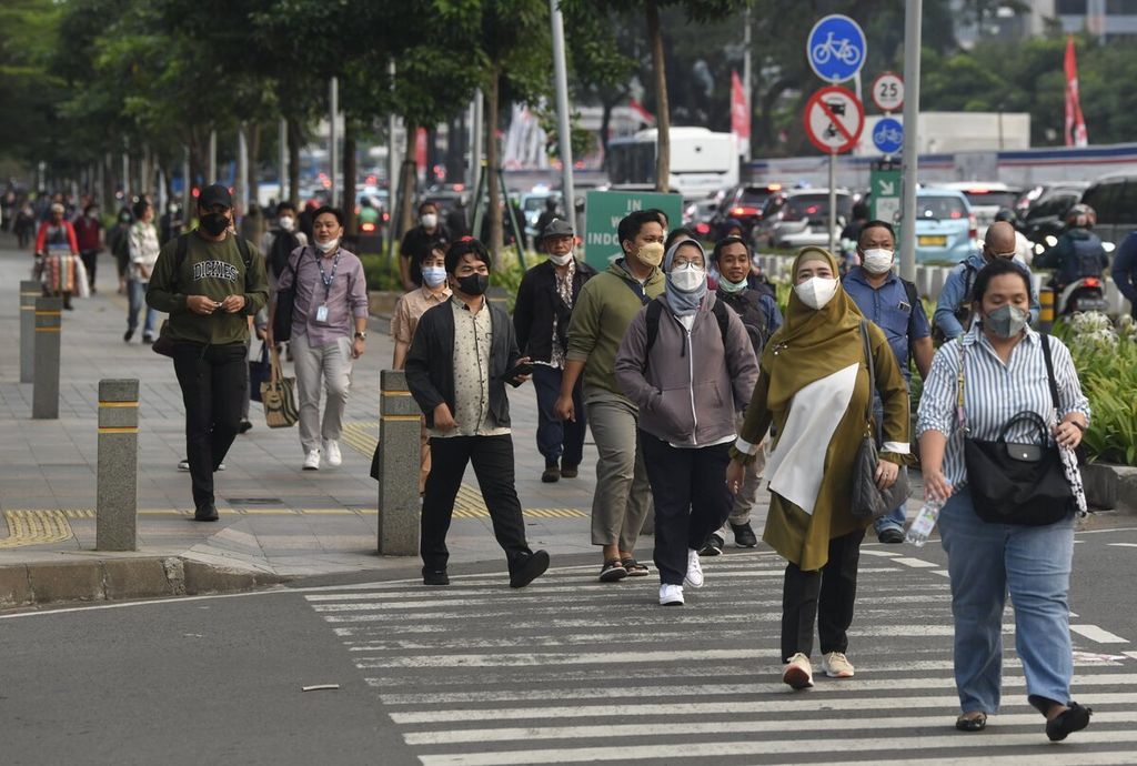 Pekerja berjalan kaki di jalur pedestrian Jalan Sudirman, Jakarta, saat jam pulang kerja, Selasa (23/8/2022). 
