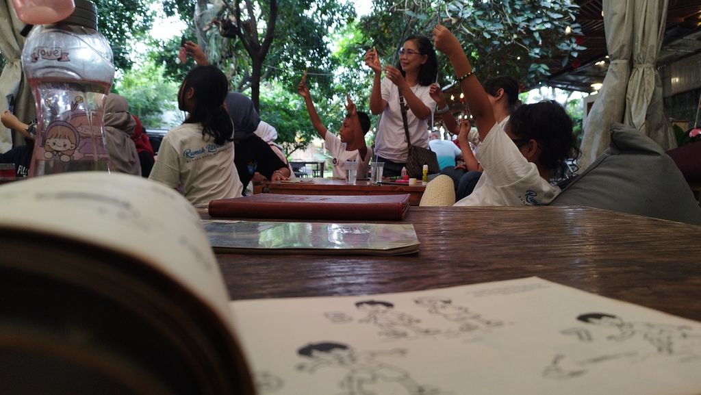 Anak-anak menunjukkan hasil karya yang mereka buat dari kertas dalam acara bertajuk membaca dan menulis bersama, di kawasan Cibubur, Kecamatan Ciracas, Jakarta Timur, Minggu (29/1/2023).