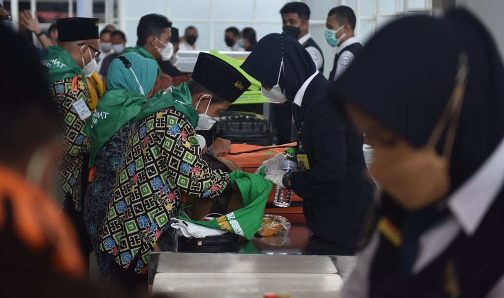 Jemaah umrah antre memeriksakan barang bawaan dan tiket di Terminal 2 Bandara Internasional Juanda Surabaya, Kabupaten Sidoarjo, Jawa Timur, Senin (14/3/2022). Setelah dua tahun terdampak pandemi Covid-19, pada 14 Maret dilakukan pemberangkatan jemaah umrah perdana melalui Bandara Juanda oleh maskapai Lion Air. 