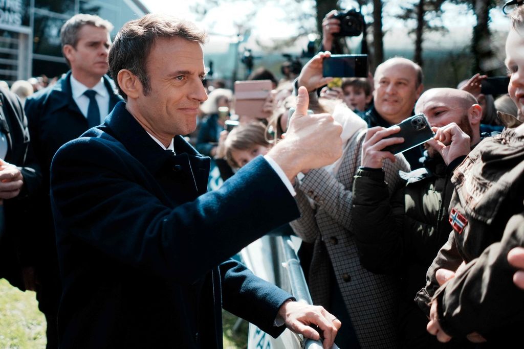 Presiden Perancis dan kandidat presiden dari partai LREM, Emmanuel Macron, mengacungkan isyarat jempol seusai melaksanakan pemungutan suara pada putaran pertama pemilihan umum presiden Perancis di sebuah tempat pemungutan suara di Le Touquet, Perancis utara, Minggu (10/4/2022). 