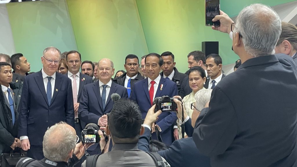Presiden RI Joko Widodo dan Kanselir Jerman Olaf Scholz bersama-sama mengelilingi Paviliun Indonesia dalam pameran industri Hannover Messe 2023, Hannover, Jerman, Senin (17/4/2023). 