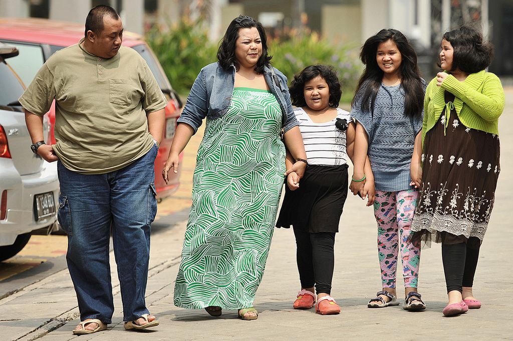 Pasangan suami istri bertubuh gemuk, Roy Febry dan Lulu Lustanti, bersama ketiga anaknya (dari tengah ke kanan), Cindha Nurnaisya Siti Akmar, Cindhe Nursyafa, dan Cindhi Nursyafiyyah, mengikuti pertemuan Komunitas Besar (Kombes) Indonesia di Serpong, Tangerang, Banten, Sabtu (3/8/2013). Saat ini, 5-25 persen anak Indonesia mengalami obesitas dengan persentase tertinggi di Jakarta sebagai Ibu Kota. 