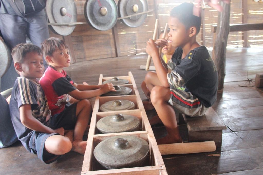 Anak-anak bermain musik di Rumah Balug, rumah adat masyarakat Dayak Bidayuh di Dusun Sebujit, Kabupaten Bengkayang, Kalimantan Barat, Rabu (13/6/2018).