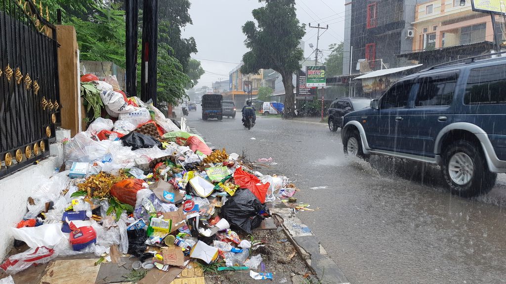 Sampah di tempat pembuangan sampah sementara meluber hingga ke badan Jalan Tompelo, Kota Kupang, Nusa Tenggara Timur, Minggu (12/12/2021).