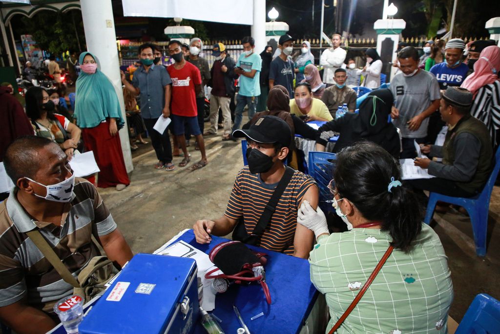 Warga menerima suntikan vaksin penguat (<i>booster</i>)<i> </i>di gerai vaksin presisi yang digelar di halaman Masjid Al-Ikhlas, Larangan Selatan, Larangan, Kota Tangerang, Banten, Sabtu (9/4/2022) malam. 