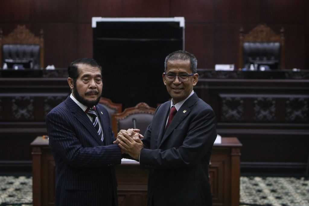 Ketua Mahkamah Konstitusi terpilih Anwar Usman (kiri) dan Wakil Ketua Mahkamah Konstitusi terpilih Saldi Isra berjabat tangan setelah Rapat Pleno Pemilihan Ketua dan Wakil Ketua Mahkamah Konstitusi Periode 2023-2028 di Gedung Mahkamah Konstitusi, Jakarta, Rabu (15/3/2023). 
