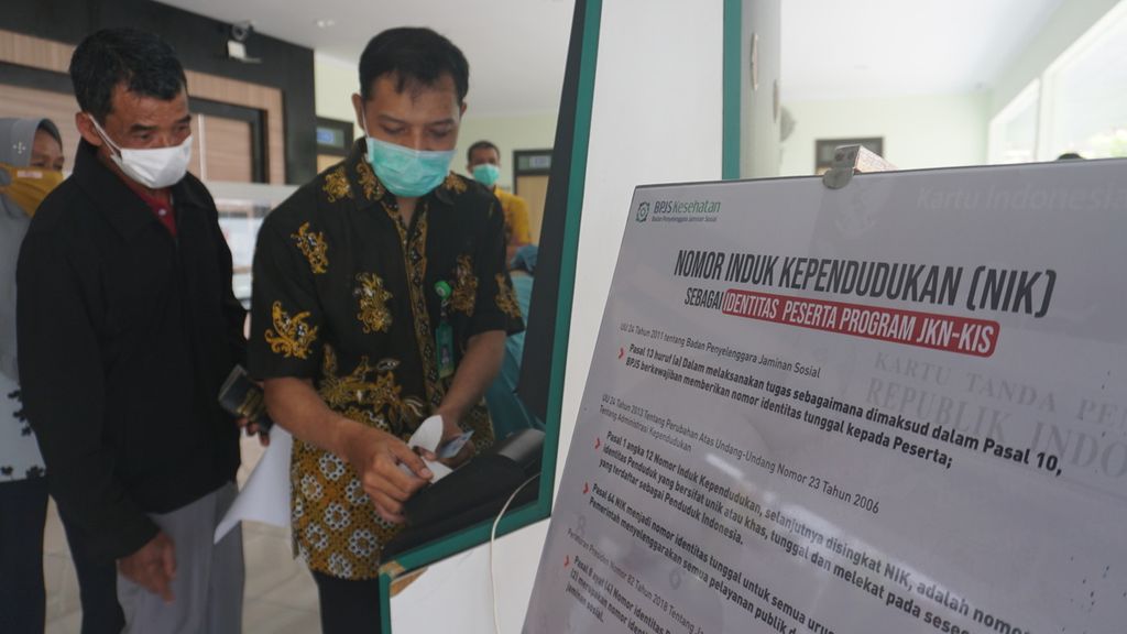 Sujadi (60) dibantu oleh petugas puskesmas sedang memasukkan data kepesertaan JKN-KIS untuk didaftarkan dalam sistem pelayanan kesehatan di Puskesmas Temon 1 Kulon Progo, Yogyakarta, Jumat (4/2/2022). Jumlah peserta program JKN-KIS yang tercatat saat ini sebanyak 223 juta orang.