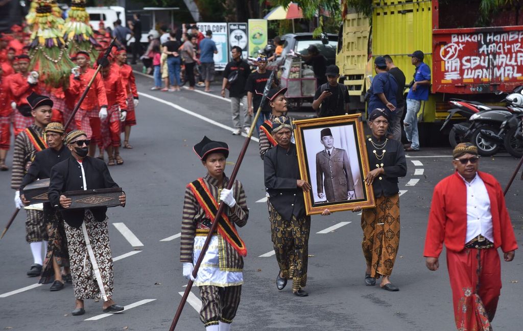 Petugas yang membawa foto Bung Karno melintasi Jalan Panglima Sudirman untuk menuju Komplek Makam Bung Karno saat Grebeg Pancasila, Kota Blitar, Jawa Timur, Rabu (1/6/2022).  