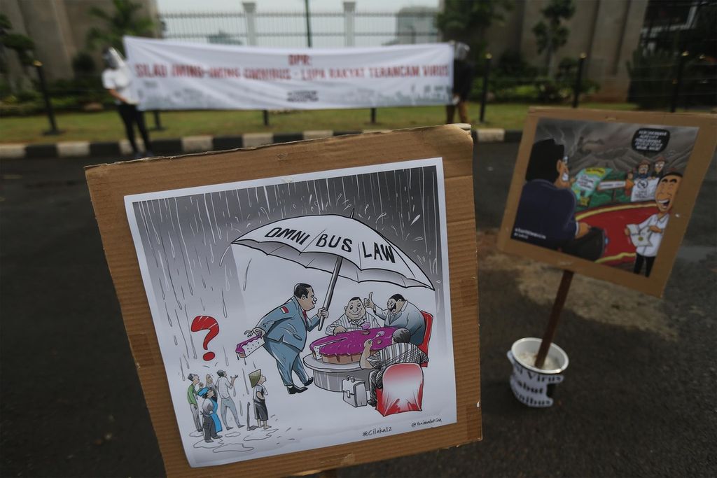 Gambar kartun berisi penolakan Rancangan Undang-Undang (RUU) Cipta Kerja dipasang oleh para aktivis dari gerakan #BersihkanIndonesia saat berunjuk rasa di depan Gedung Parlemen, Jakarta, Selasa (14/7/2020). 