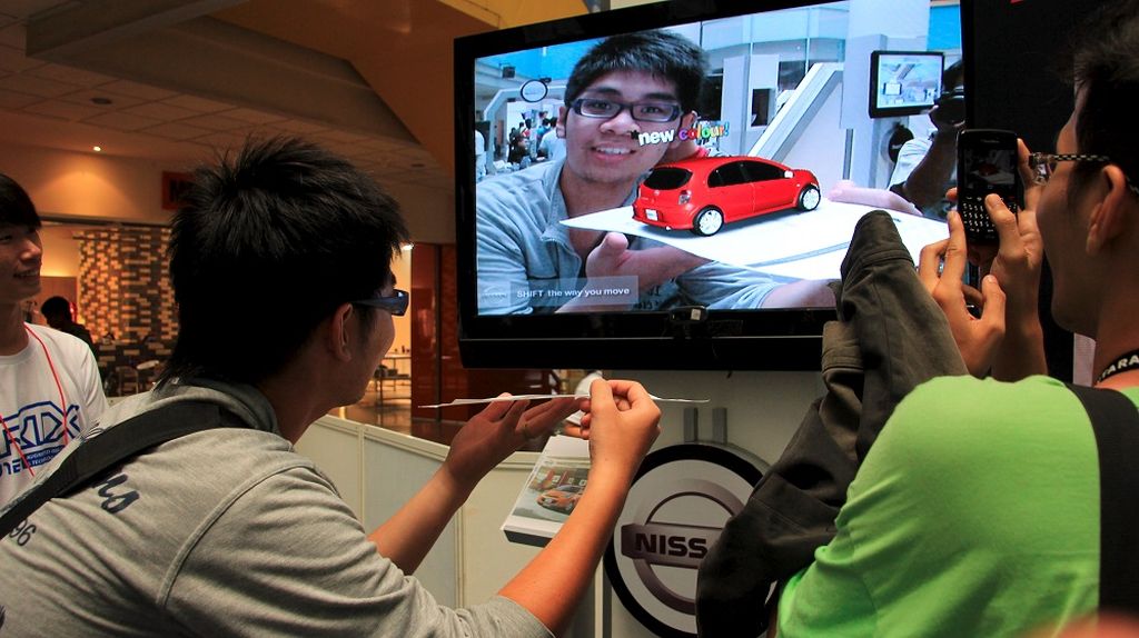 Seorang pengunjung sedang menikmati teknologi realitas tertambahkan atau augmented reality dari sebuah produk di Pameran Augmented Reality pada Jumat (15/6/2012). Pameran pertama di Asia ini digelar di kampus Universitas Bina Nusantara, Jakarta.