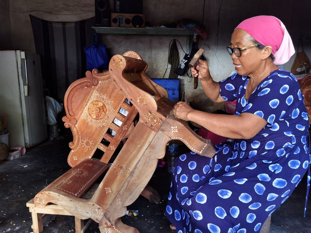 Hafizah (55), sculpts motifs on chairs for cukli crafts at her home in Lendang Re, Sayang-Sayang Village, Cakranegara District, Mataram City, West Nusa Tenggara, Friday (19/5/2023).