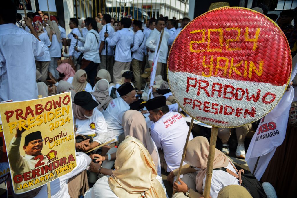 Simpatisan Partai Gerindra membawa poster dan nyiru bertuliskan "Prabowo Presiden" saat mengiringi pendaftaran bakal calon legislatif di depan Gedung KPU, Jakarta, Sabtu (13/5/2023). 