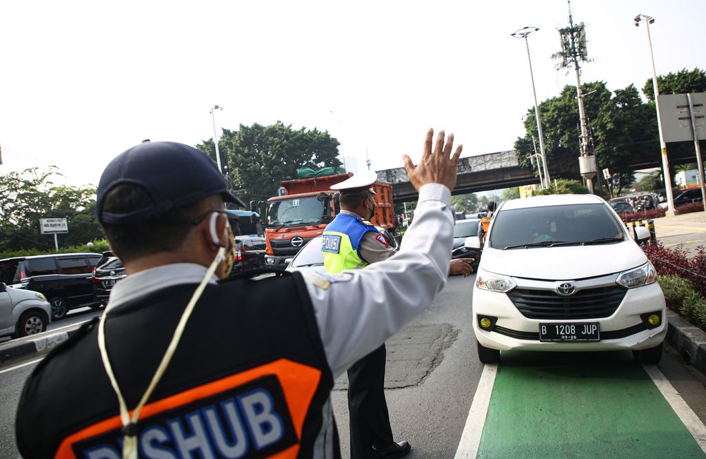 Petugas memberhentikan kendaraan roda empat yang pelat nomor polisinya tidak sesuai ketentuan melintas di kawasan ganjil genap di Jalan Fatmawati, Jakarta Selatan, Senin (25/10/2021). Jalan Fatmawati menjadi satu dari 13 ruas jalan yang diberlakukan sistem ganjil genap.