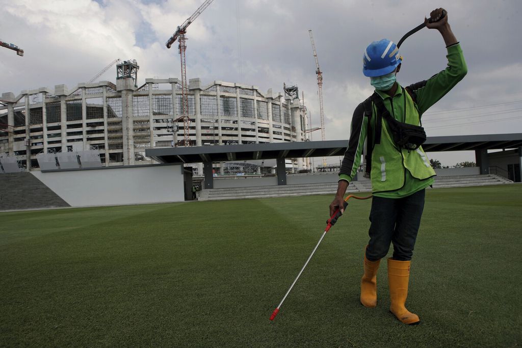 Pekerja melakukan perawatan rumput di luar Jakarta International Stadium (JIS), Tanjung Priok, Jakarta Utara, Rabu (16/6/2021). 