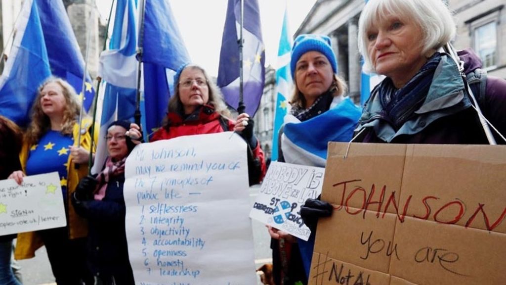 Para pengunjuk rasa memperlihatkan poster berisi tuntutan dan pendapat di luar gedung Mahkamah Agung, tempat berlangsungnya sidang untuk memaksa Perdana Menteri Inggris Boris Johnson menunda Brexit, di Edinburgh, Inggris, Senin (21/10/2019).
