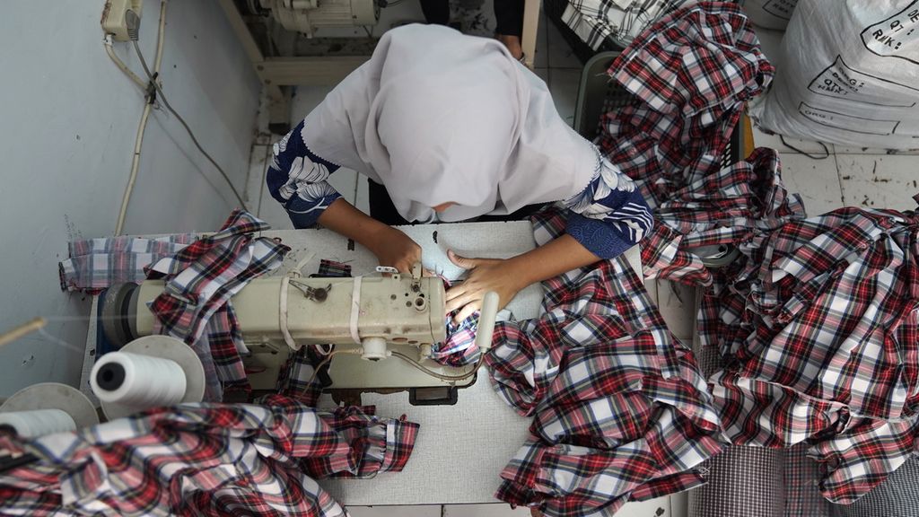 Aktivitas pekerja menjahit pakaian di GGS Fashion di Perkampungan Industri Kecil (PIK) Pulogadung, Penggilingan, Cakung, Jakarta Timur, Kamis (3/11/2022). Usaha kecil dan menengah garmen di kawasan tersebut dalam tiga bulan terakhir ordernya mengalami penurunan. Pekerja dibayar borongan tiap minggu Rp 150 ribu hingga Rp 300 ribu tergantung tingkat kesulitan dan jumlah produk yang dihasilkan. Pengusaha terkendala oleh keterbatasan bahan baku kain lokal yang tidak banyak variasinya. 
