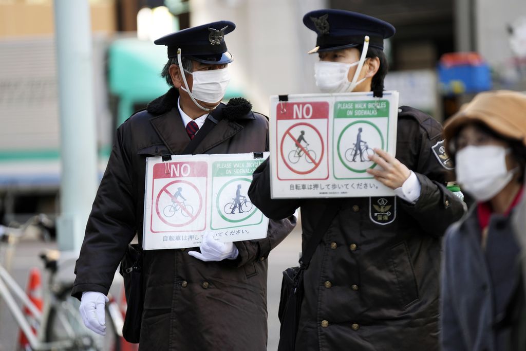 Petugas keamanan mengenakan masker pelindung saat bertugas di salah satu sudut Tokyo, Jepang, Senin (31/1/2022). Penyakit hepatitis misterius pada anak kini juga dilaporkan terjadi di Jepang.