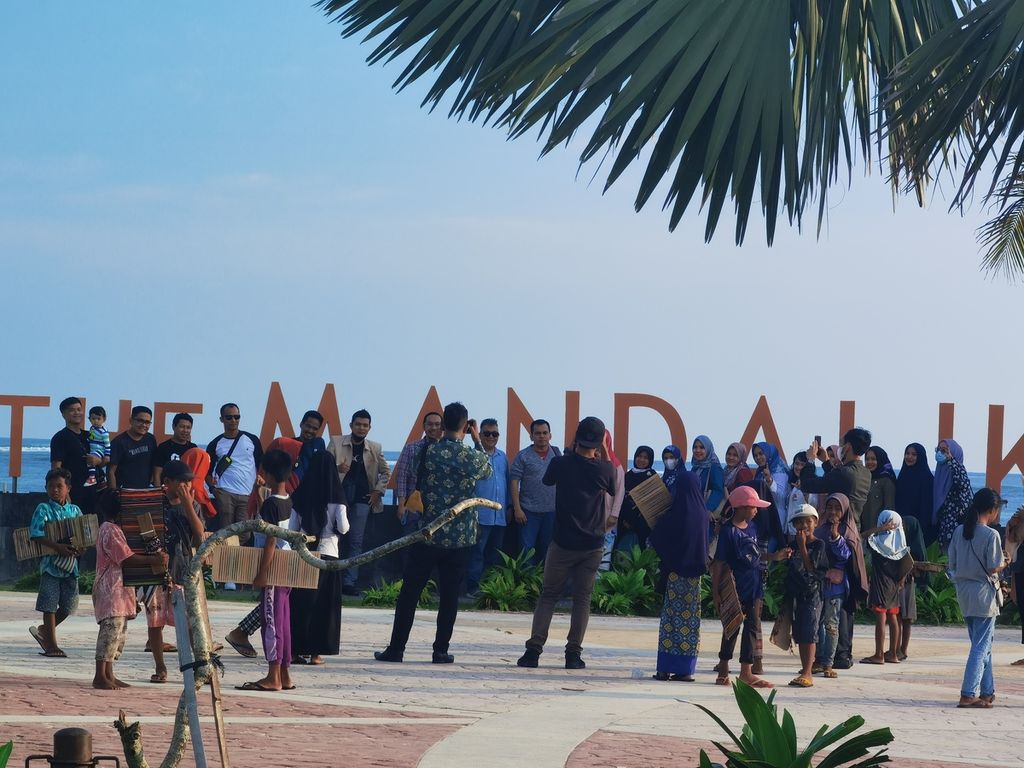 Rombongan wisatawan asal Padang, Nusa Tenggara Barat, berfoto di Kawasan Pantai Kuta Mandalika, Kuta, Pujut, Lombok Tengah, Nusa Tenggara Barat, Kamis (24/3/2022).