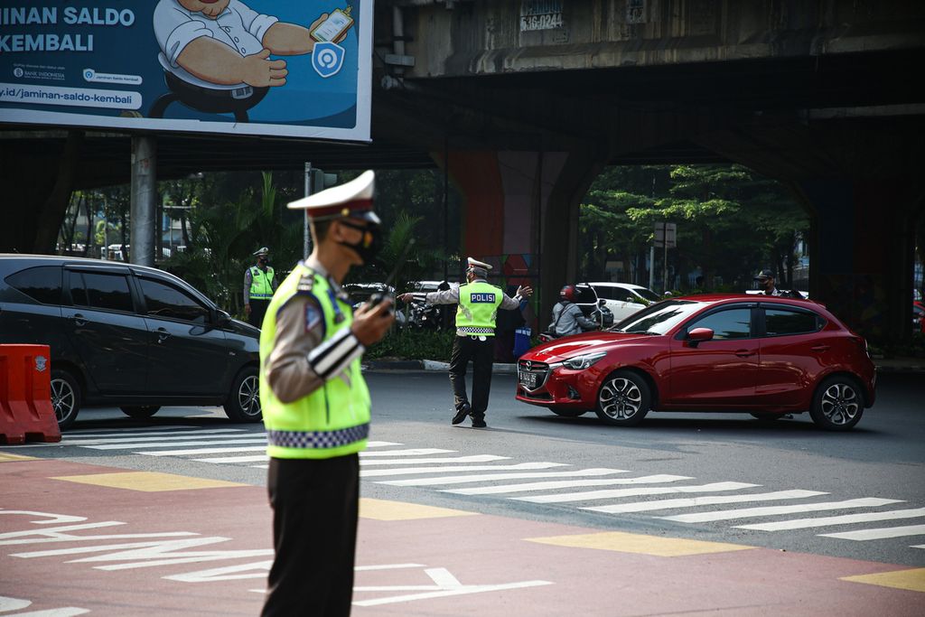 Petugas polisi mengarahkan kendaraan untuk keluar dari Jalan Fatmawati, Jakarta, yang diberlakukan sistem ganjil genap, Senin (25/10/2021). Masih banyak pengemudi kendaraan roda empat yang belum memahami titik-titik baru yang diberlakukan sistem ganjil genap.