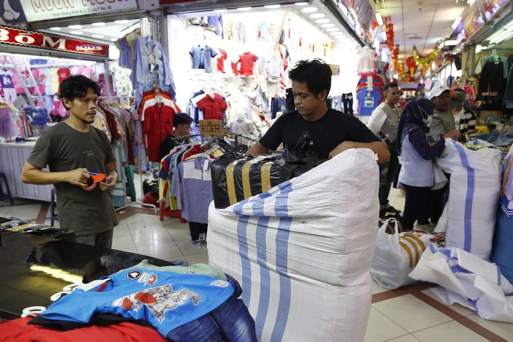 Pegawai salah satu kios di pasar grosir tekstil Blok A Tanah Abang, Jakarta, sedang mengepak pakaian pesanan pelanggan, Senin (30/1/2023). Untuk persiapan menjelang Lebaran, para pedagang di daerah terutama dari luar Pulau Jawa mulai menyetok barang dengan berbelanja pakaian di Pasar Tanah Abang. 