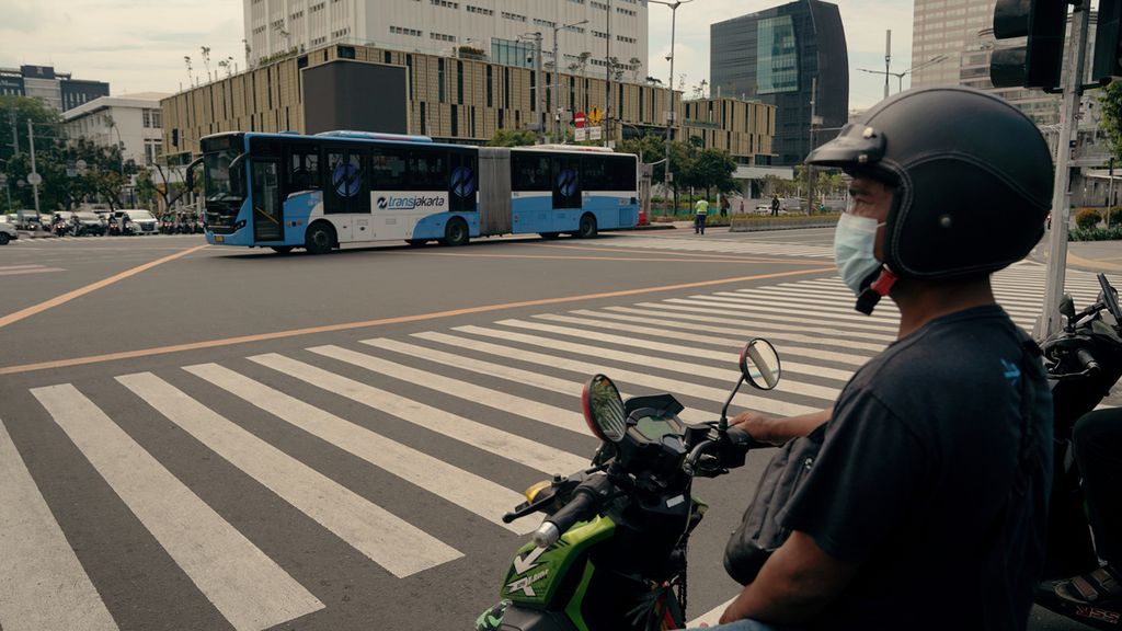 Bus Transjakarta melintas di perempatan Jalan Thamrin, Jakarta Pusat, Selasa (8/3/2022). Wilayah aglomerasi Jabodetabek kembali menerapkan PPKM level 2. 