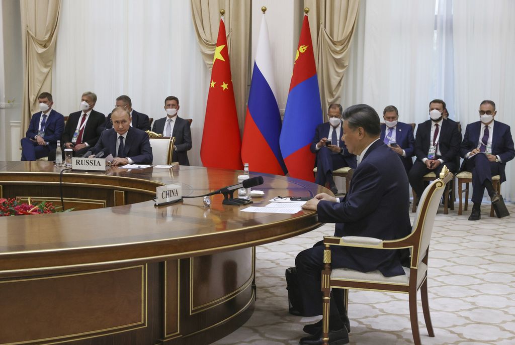 Presiden China Xi Jinping (kanan, samping meja) dan Presiden Rusia Vladimir Putin (ketiga dari kiri) menghadiri pertemuan trilateral dengan Presiden Mongolia Ukhnaa Khurelsukh (tidak terlihat) dalam pertemuan di sela-sela KTT Organisasi Kerja Sama Shanghai (SCO) di Samarkand, Uzbekistan, Kamis (15/9/2022). 