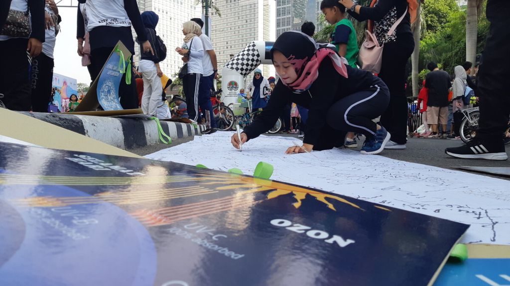 Warga yang berada di kawasan hari bebas kendaraan bermotor (<i>car free day</i>) Jalan Imam Bonjol, Jakarta, menandatangani dukungan untuk menjaga lapisan ozon pada perayaan Hari Ozon Internasional, Minggu (16/9/2018).
