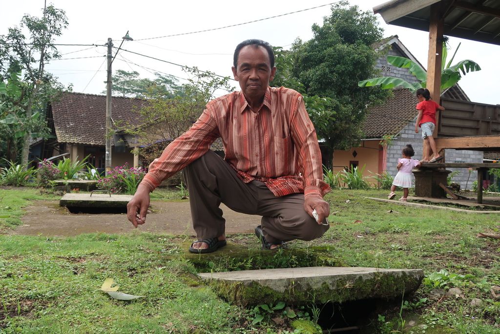 Joko Waluyo berpose di depan salah satu sumur resapan di pekarangan rumahnya, Rabu (20/4/2022). Joko adalah penggerak sumur resapan di Desa Patemon, Tengaran, Kabupaten Semarang, Jawa Tengah, yang membantu mengatasi krisis air di Patemon sekitar satu dekade silam.
