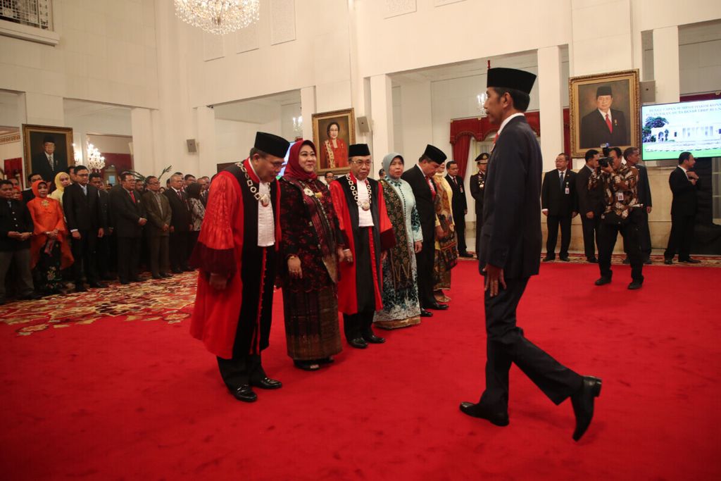 Presiden Joko Widodo menyampaikan ucapan selamat kepada Hakim Konstitusi Aswanto dan Wahiduddin Adams seusai mengucapkan sumpah di Istana Negara, Jakarta, 21 Maret 2019. 