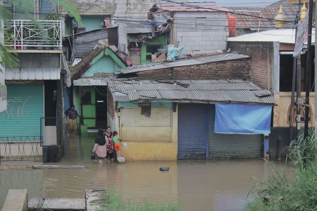 Sejumlah warga melintasi banjir di Kelurahan Andir, Kecamatan Baleendah, Kabupaten Bandung, Rabu (3/11/2021).