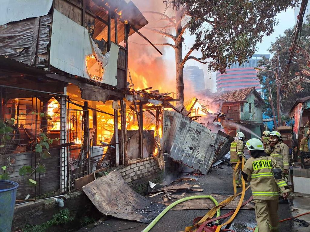 Petugas memadamkan api yang melalap bangunan di Jalan Edi IX, Setiabudi, Jakarta Selatan, Minggu (12/3/2023).