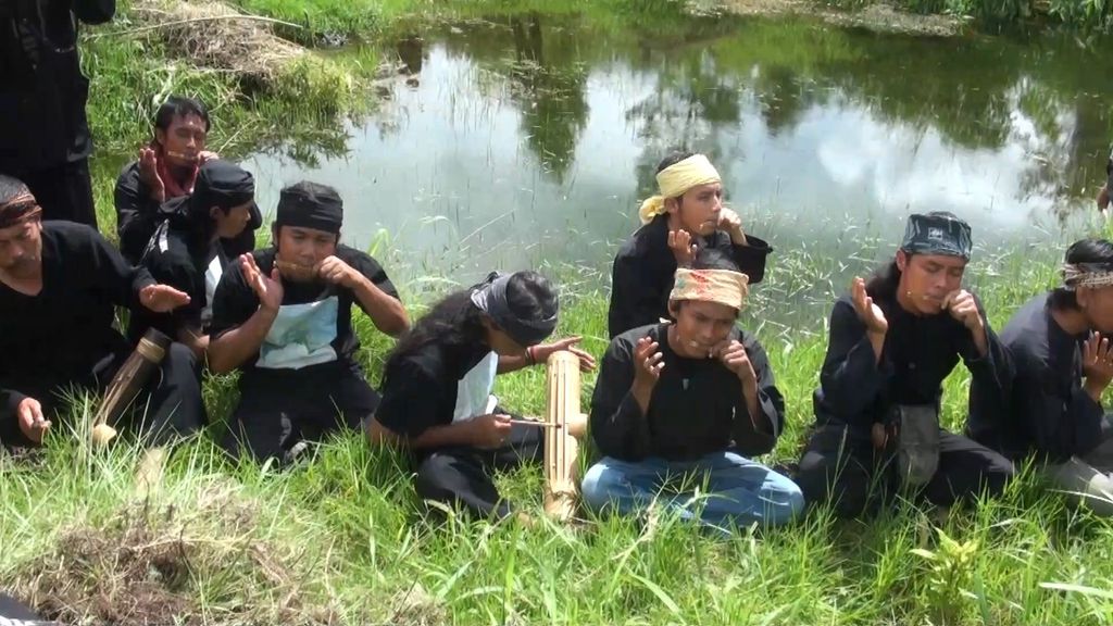 Pegiat Patanjala memainkan iringan Kidung Pangauban dengan alat musik Karinding di Desa Laksana, Ibun, Kabupaten Bandung, 7 Februari 2015. Kidung Pangauban itu adalah musik pengiring selama proses penanaman tanaman endemik yang menjadi batas area hutan larangan, tutupan, dan baladahan menurut kearifan lokal Patanjala.