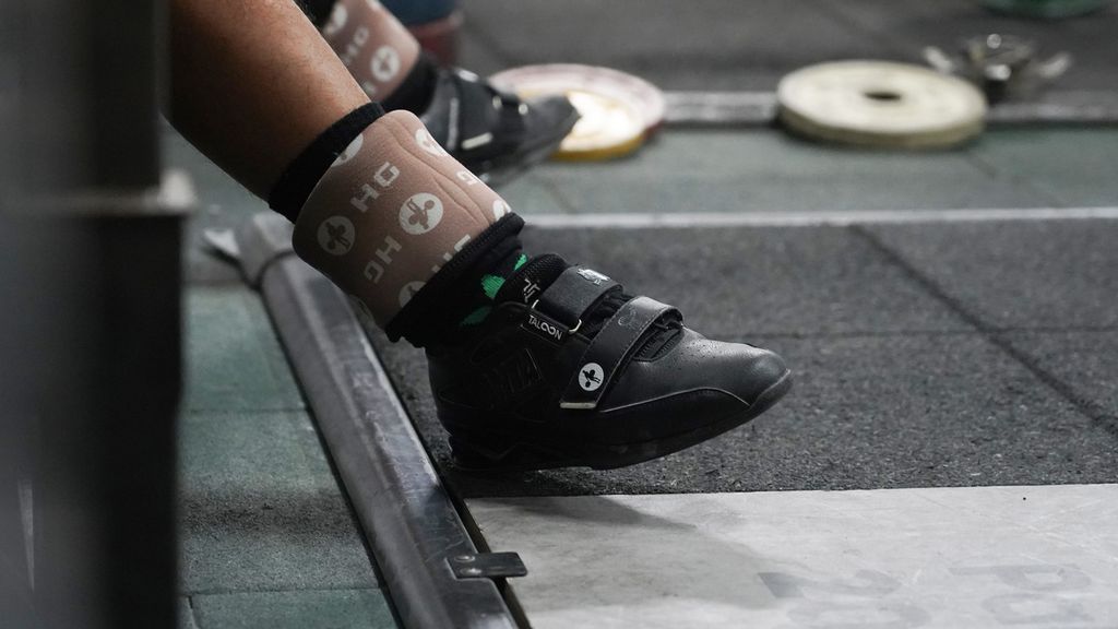 Sepatu khusus atlet angkat besi yang digunakan lifter nasional Rahmat Erwin Abdullah ketika mengikuti latihan di pelatnas angkat besi PB PABSI di Mako Marinir TNI AL, Jakarta, Senin (25/4/2022).