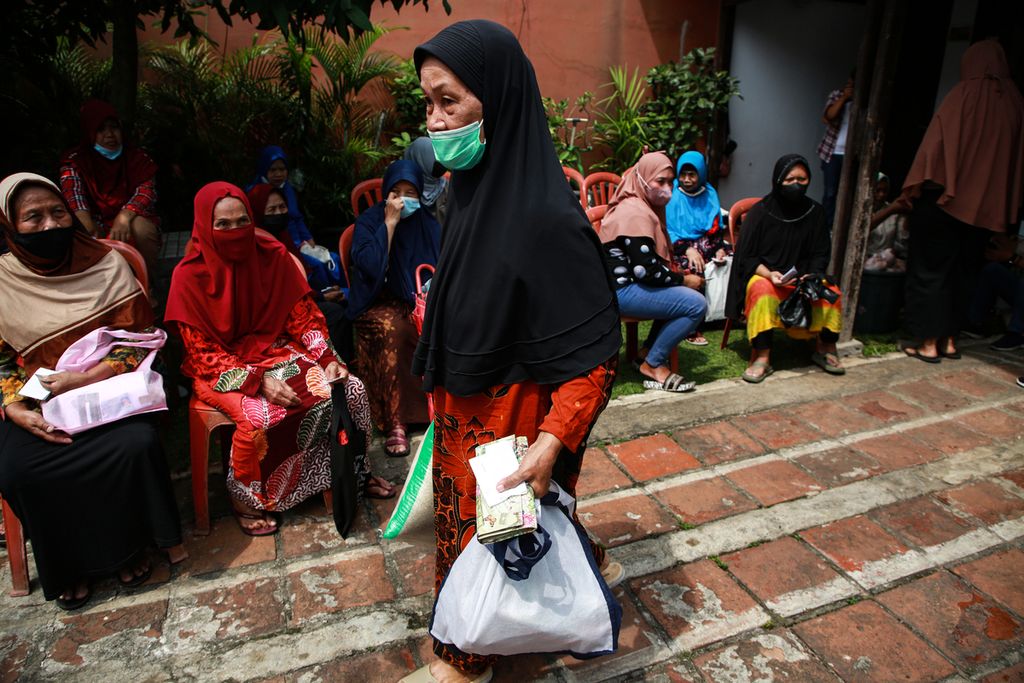 Warga membawa sembako dalam kegiatan penyaluran sembako murah di Kelurahan Larangan Indah, Larangan, Kota Tangerang, Banten, September 2022. 