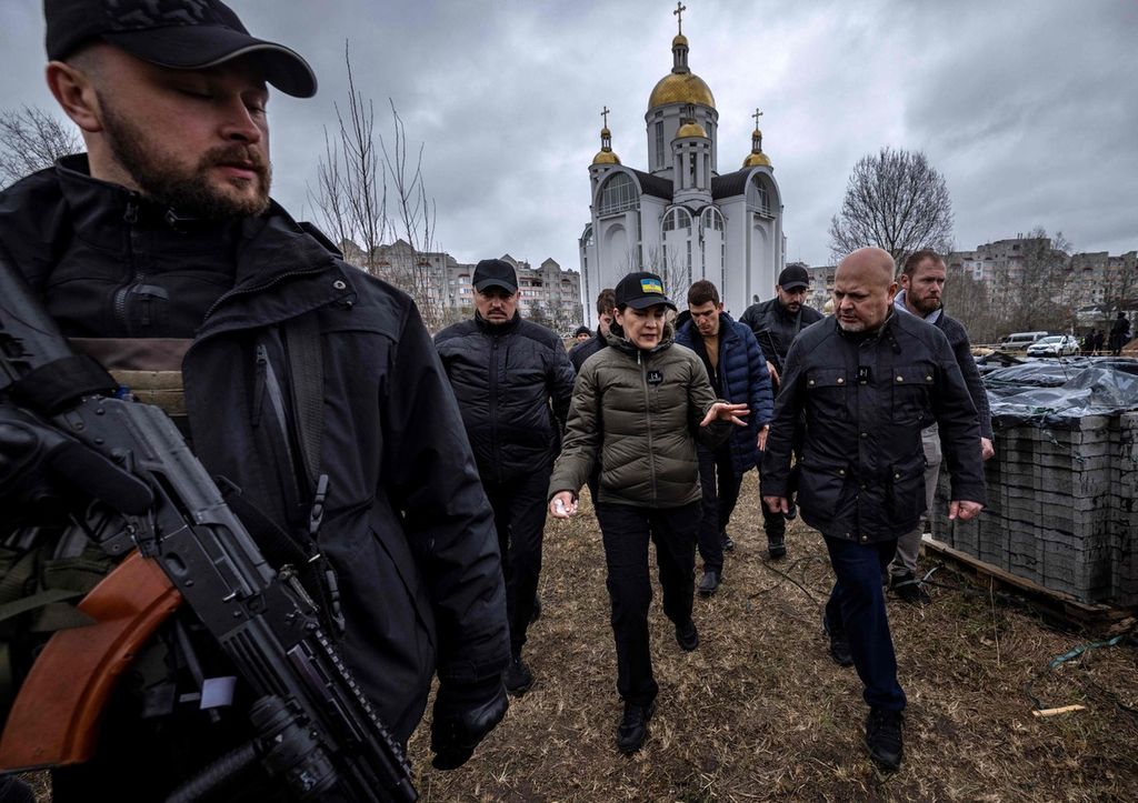 Jaksa Agung Ukraina, Iryna Venediktova (tengah) dan Jaksa Penuntut dari Pengadilan Kejahatan Internasional, Karim Khan (kanan) mengunjungi lokasi pemakaman massal di Gereja Saint Andrew di Bucha, Kiev pada Rabu (13/4/2022).