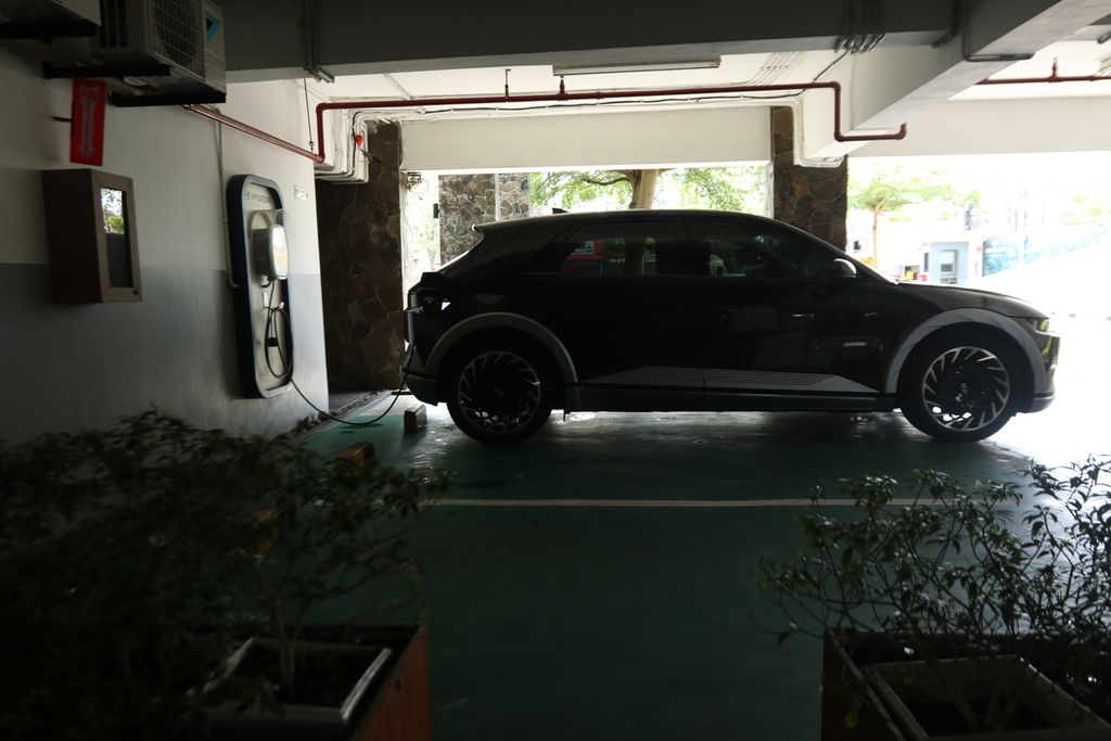 Mobil listrik yang digunakan Tim Jelajah Energi dan Vakansi harian Kompas mengisi daya di parkiran Santika Hotel Banyuwangi, Minggu (11/9/2022). Hotel Santika Banyuwangi menyediakan fasilitas gratis <i>charging</i> bagi tamu yang menginap.