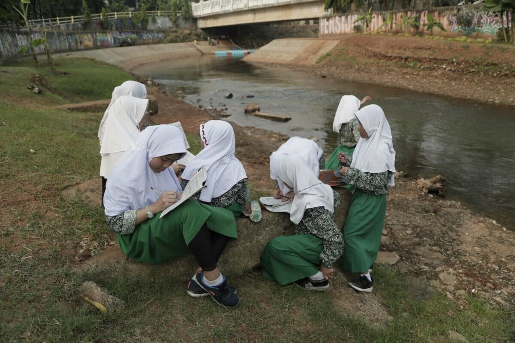 Siswa kelas VI Madrasah Ibtidaiyah Al Hidayah melakukan penelitian sederhana seusai pulang sekolah di Kali Pesanggrahan, Lebak Bulus, Jakarta, Kamis (25/7/2019). Penelitian tersebut merupakan bagian dari mata pelajaran pendidikan lingkungan dan budaya Jakarta. 