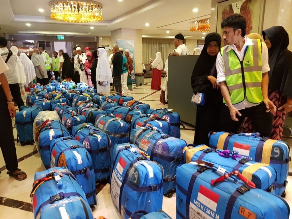 Petugas memeriksa dan menimbang koper jemaah sebelum diangkut ke Bandara King Abdul Aziz Jeddah, Arab Saudi, Minggu (26/8/2018).