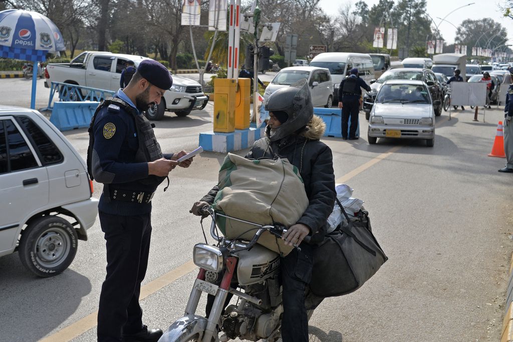 Polisi memeriksa dokumen seorang kurir di pos pemeriksaan di luar jalan raya di Islamabad, Pakistan, 31 Januari 2023. Keamanan diperketat setelah serangan bom bunuh diri di sebuah masjid di kompleks kepolisian di Peshawar yang menewaskan sekitar 100 orang. 