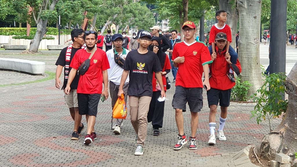 Suporter timnas Indonesia berjalan menuju ke Stadion Utama Gelora Bung Karno, Senayan, Jakarta saat pertandingan Piala AFF melawan Thailand pada Kamis (29/12/2022).